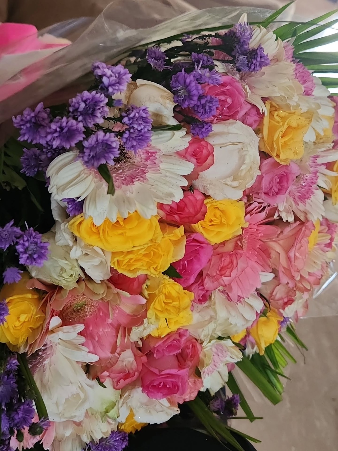 Close view of a colourful mixed flower bouquet with purple, pink, yellow, and white blooms