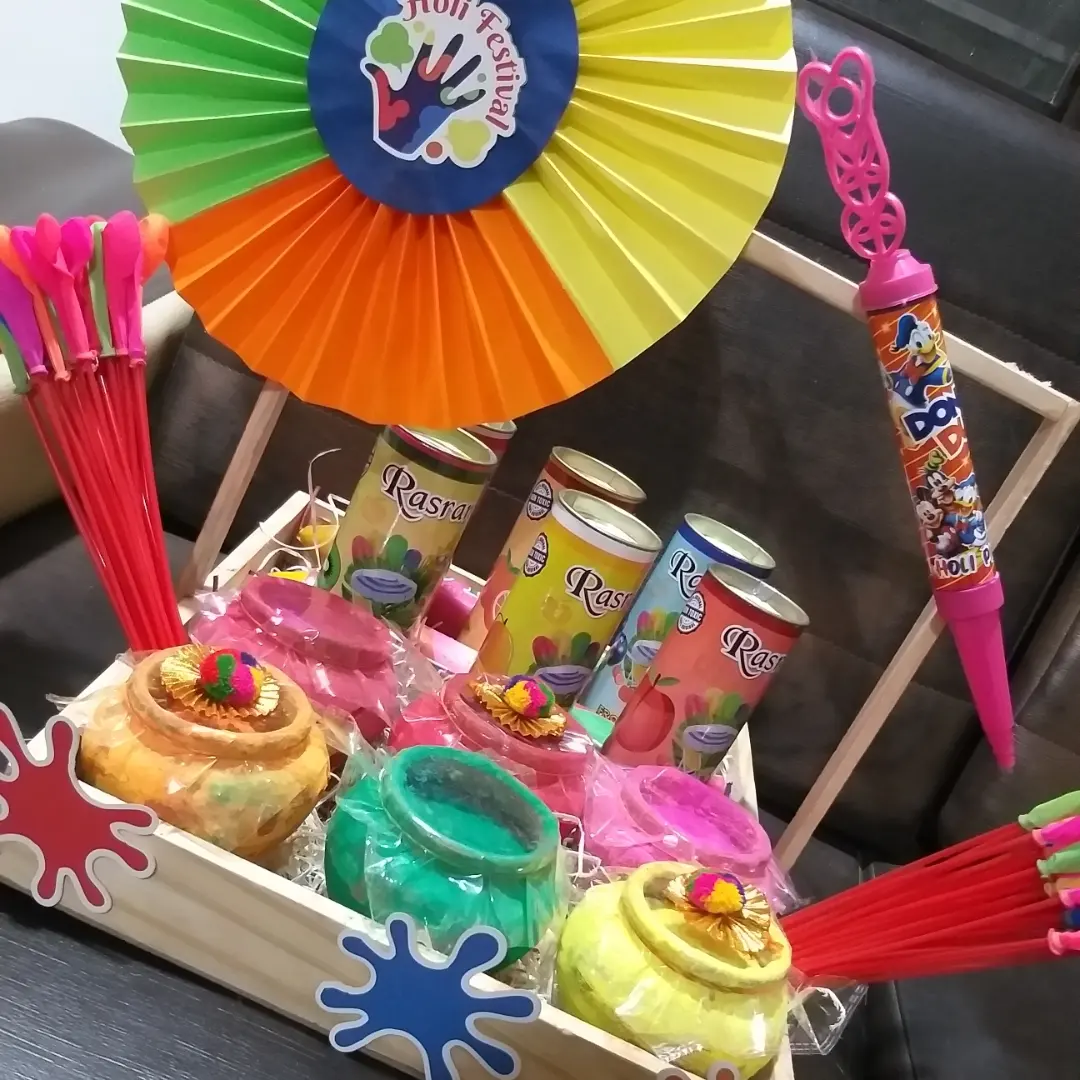 Colourful Holi hamper with paper fan, bright treats, and playful festive decorations