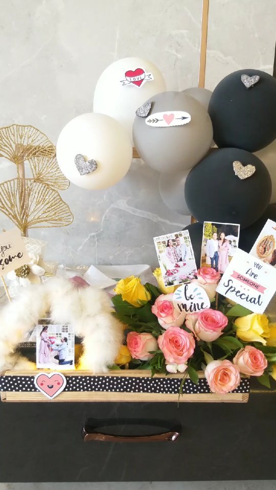 Romantic hamper with pink roses, heart balloons, photographs, and handwritten cards