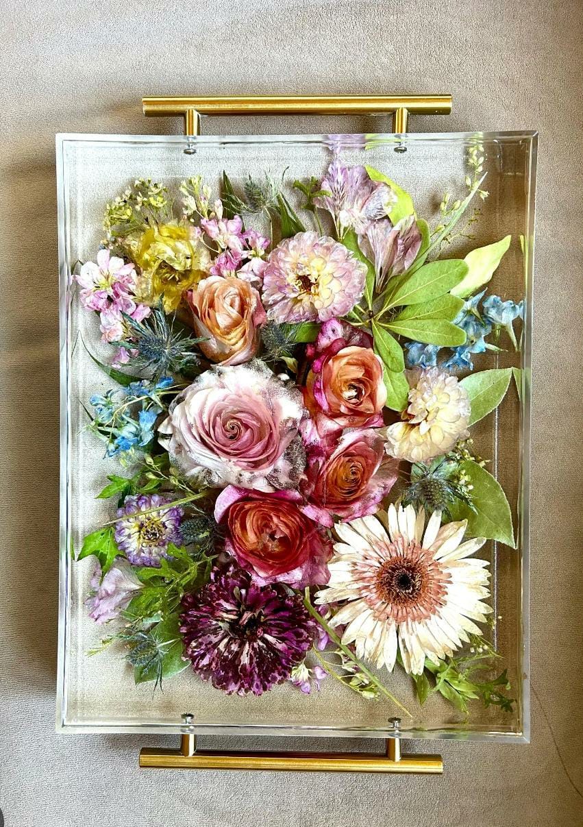 Clear handled resin tray with a colourful pressed-flower arrangement