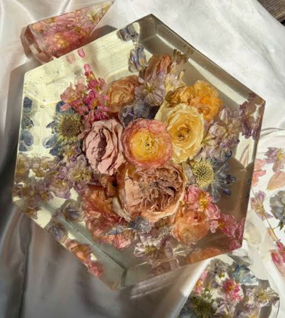 Hexagonal resin keepsake with pressed flowers in pink, peach, and lilac tones