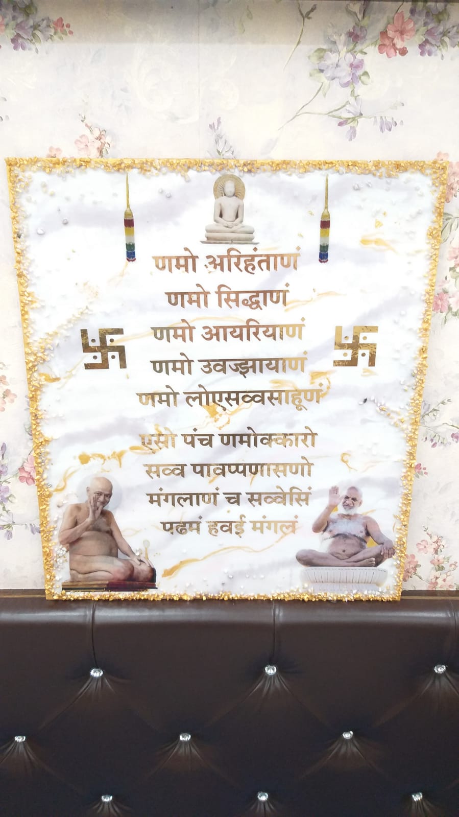 White and gold resin frame with a Jain mantra design, figures, and textured border